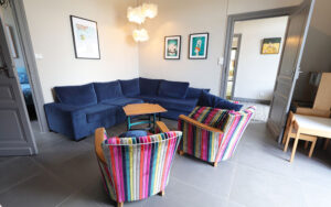 Gezellige woonkamer met blauwe bank en kleurrijke stoelen in Dordogne.