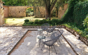 Gezellige tuin met zitje en oude muur in Dordogne.