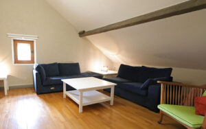 Gezellige woonkamer in luxe vakantiehuis met houten vloer en moderne meubels.