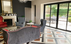 Luxe woonkamer met grote glazen deuren en elegante meubels.