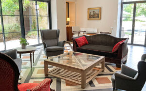 Luxe woonkamer met grote ramen, comfortabele stoelen en elegante inrichting.
