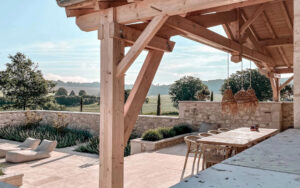 Luxe Vakantiehuis Dordogne terras Uitzicht op het terras van een luxe vakantiehuis in Dordogne met houten structuur en tuin.