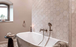 Luxe badkamerruimte in Dordogne Luxe vrijstaand bad in een moderne badkamer met hexagon tegels en houten plafond.