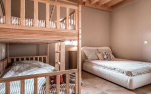 Gezinsvriendelijke slaapkamer in Domaine Lèisa Ruime slaapkamer met houten stapelbed en groot bed in Domaine Lèisa.